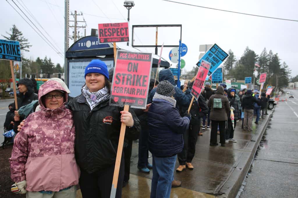 people holding signs and posing with line of people behind them
