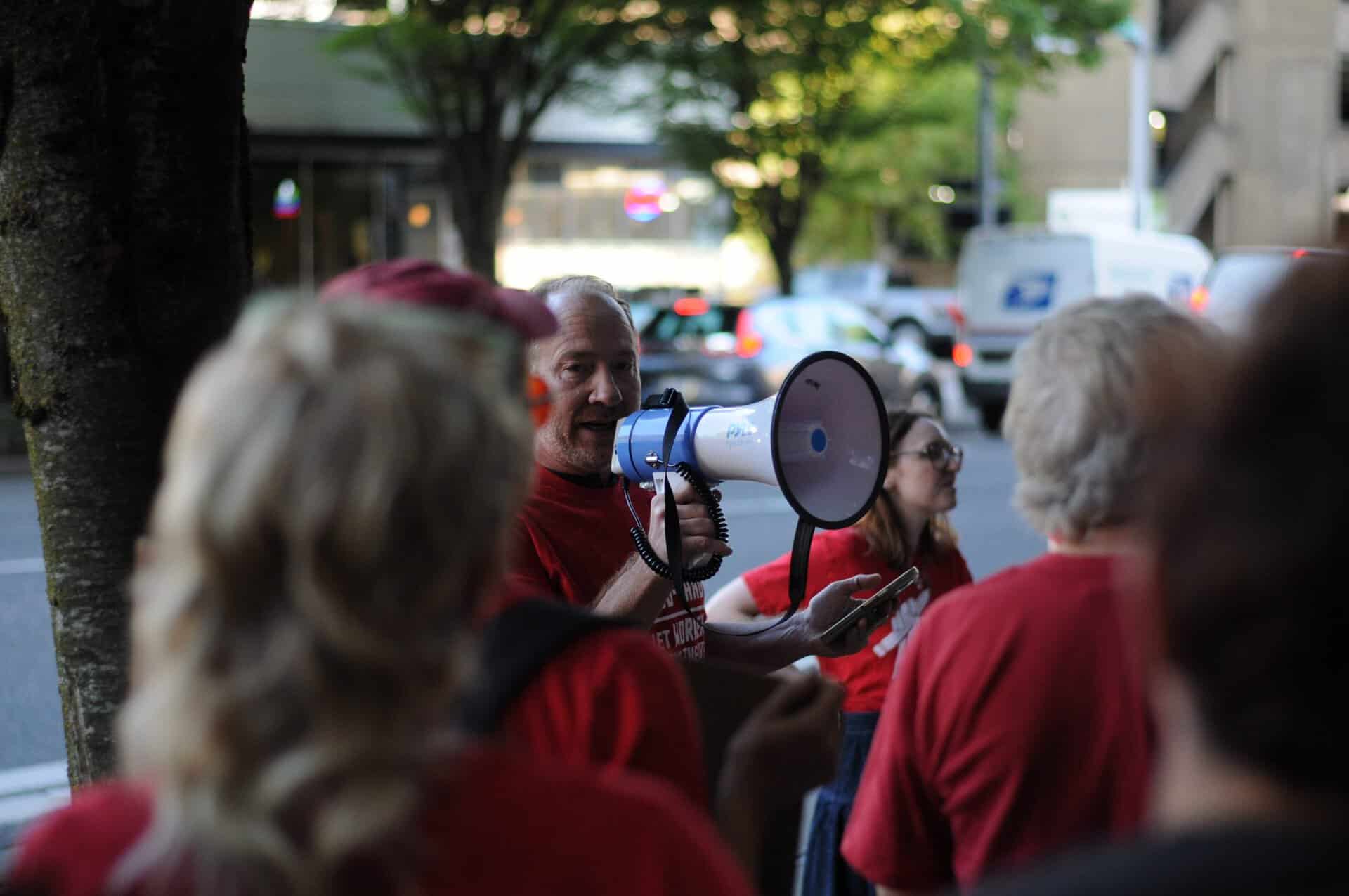 person on bullhorn addressing a crowd